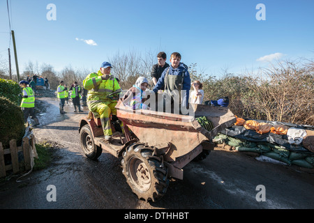 Volunteer aid workers help distribute supplies in the flooded village of Moorland on the Somerset Levels. Stock Photo