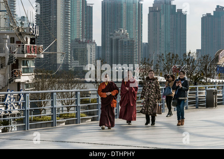 Monks and tourists walking along The Bund, Shanghai, China Stock Photo