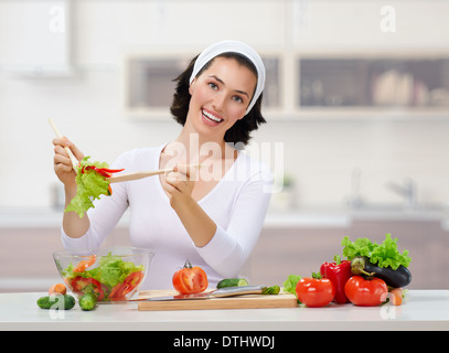 woman in kitchen making salad Stock Photo