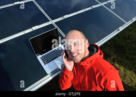 engineer using laptop at solar panels plant field Stock Photo