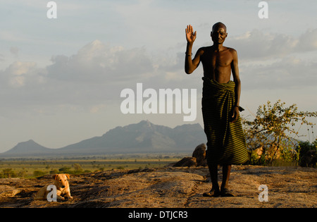 Uganda Karamoja Kotido, Karimojong people, pastoral tribe, warrior in front of mountain range Stock Photo