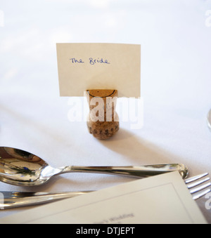 Top table at a wedding banquet An upside down cork with a name tag for the bride Silver fork and spoon England Stock Photo