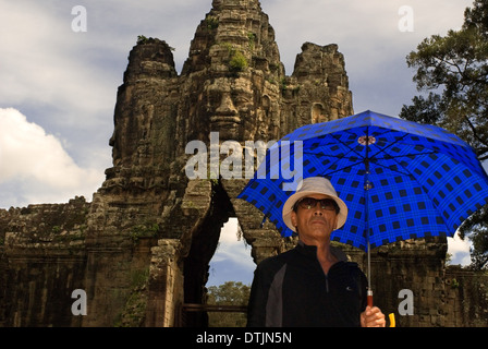 Asian Tourist in the gateway to Angkor Thom. Angkor Thom is undeniably an expression of the highest genius. It is, in three dime Stock Photo