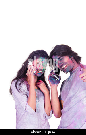 Couple talking on mobile phones on Holi Stock Photo