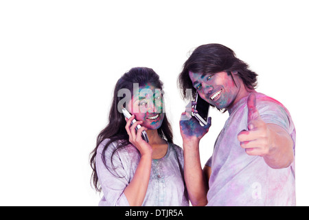 Couple talking on mobile phones on Holi Stock Photo