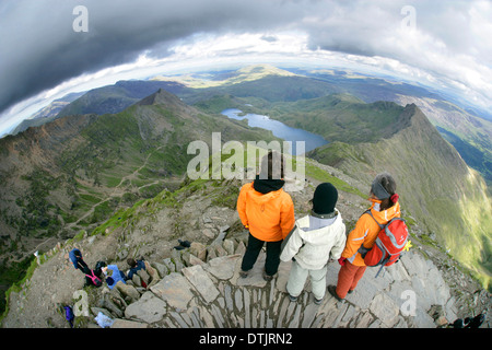 Three people stood at the top of a mountain, Snowdon, North Wales. Stock Photo