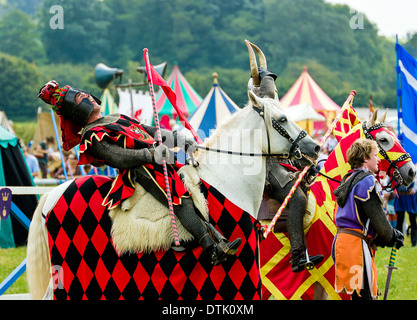 Man on horseback dressed as medieval knight  leans back with laughter at summer country show in Somerset England United Kingdom. Stock Photo