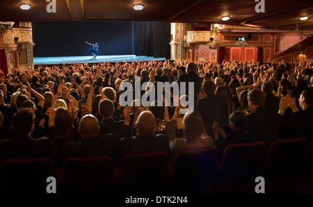 Audience applauding ballerina on stage in theater Stock Photo