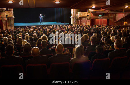 Audience watching performer on stage in theater Stock Photo