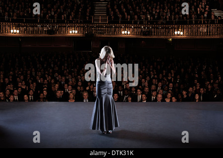 Performer with head in hands on stage in theater Stock Photo