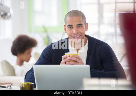 Man using laptop at table Stock Photo