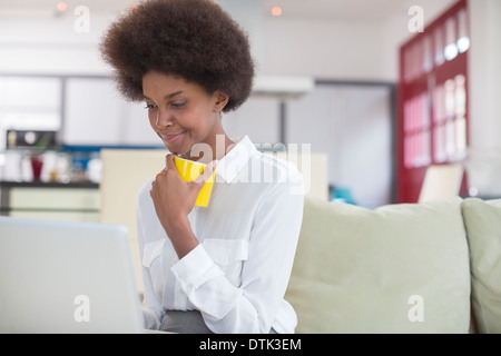 Businesswoman using laptop at breakfast Stock Photo
