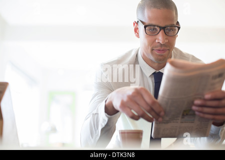 Businessman reading newspaper at breakfast Stock Photo