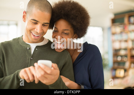 Couple using cell phone together Stock Photo