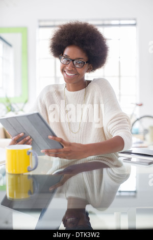 Woman using digital tablet at table Stock Photo