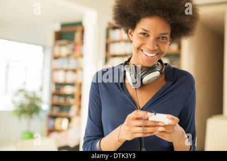 Woman listening to headphones in living room Stock Photo