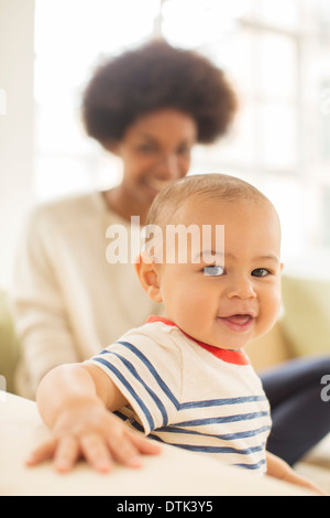 Mother and baby boy sitting on sofa