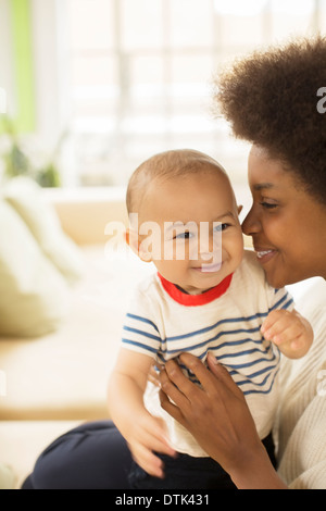 Mother holding baby boy on sofa Stock Photo