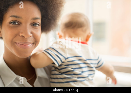 Smiling mother holding baby boy Stock Photo