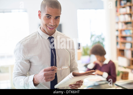 Businessman reading newspaper in living room Stock Photo