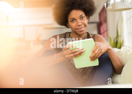 Woman using digital tablet on sofa Stock Photo