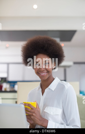 Businesswoman drinking coffee in kitchen Stock Photo