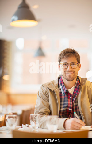 Man making notes in cafe Stock Photo
