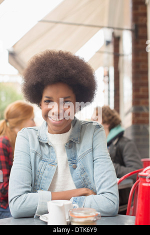 Woman drinking cup of coffee at sidewalk cafe Stock Photo