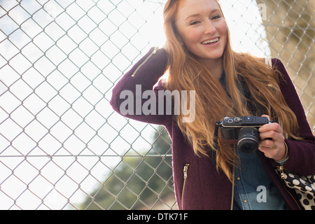 Woman holding camera outdoors Stock Photo