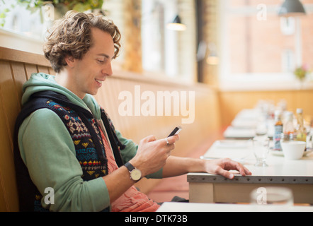 Man using cell phone in cafe Stock Photo