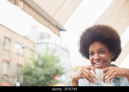 Woman drinking coffee at sidewalk cafe Stock Photo