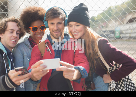 Friends taking self-portrait with camera phone outdoors Stock Photo