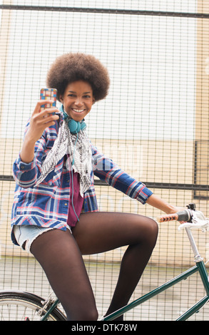 Woman taking self-portrait on bicycle Stock Photo