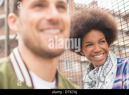Man and woman smiling near fence Stock Photo