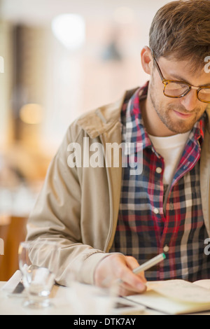 Man writing in cafe Stock Photo