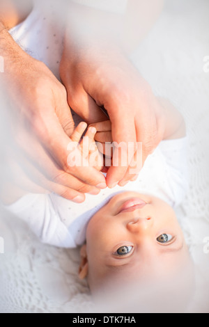 Father holding baby boy's hands Stock Photo