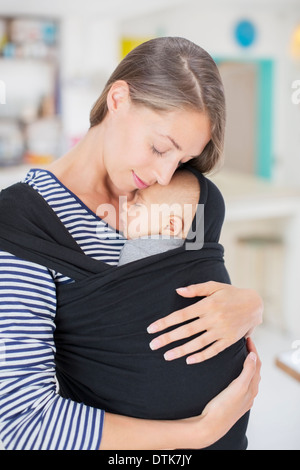 Mother holding baby in sling Stock Photo