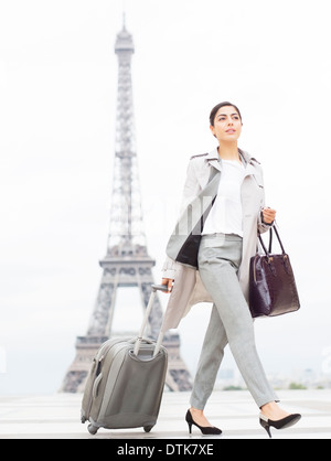 Businesswoman walking past Eiffel Tower, Paris, France Stock Photo