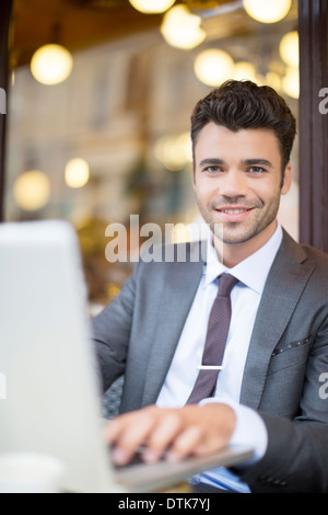 Businessman using laptop in sidewalk cafe Stock Photo