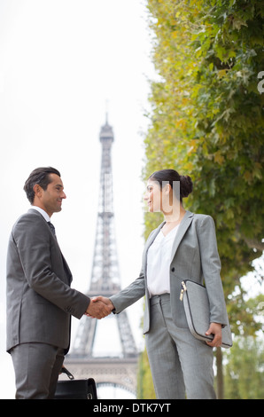 Business people shaking hands near Eiffel Tower, Paris, France Stock Photo