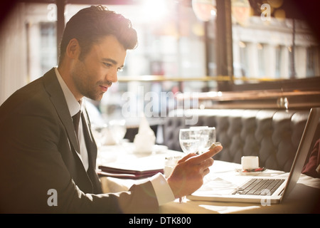Businessman using laptop in restaurant Stock Photo
