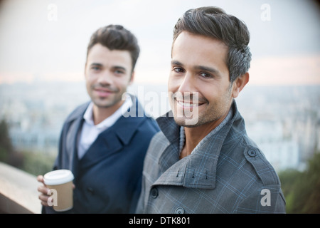 Businessmen smiling with city in background Stock Photo