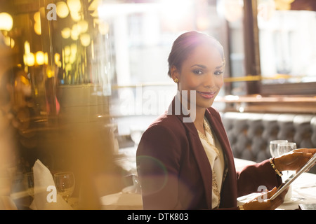 Businesswoman using digital tablet in restaurant Stock Photo