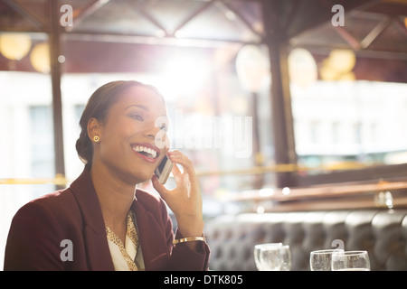 Businesswoman talking on cell phone in restaurant Stock Photo