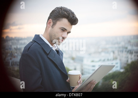 Businessman using digital tablet overlooking Paris, France Stock Photo