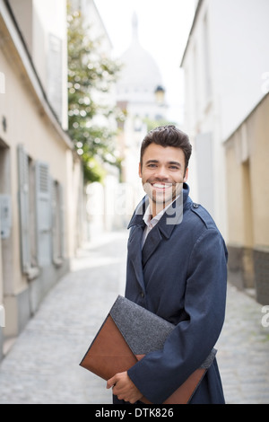 Businessman smiling on street with Sacre Coeur Basilica in background, Paris, France Stock Photo