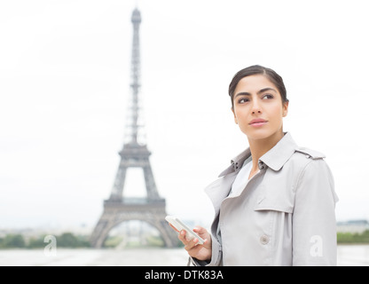 Businesswoman using cell phone near Eiffel Tower, Paris, France Stock Photo