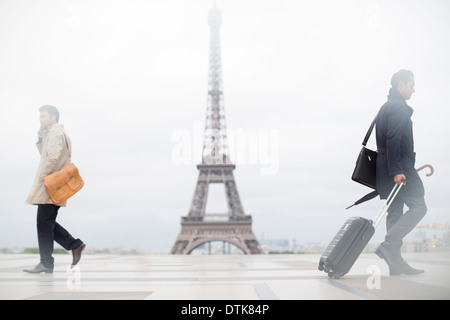Business people walking past Eiffel Tower, Paris, France Stock Photo