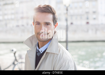 Businessman smiling along Seine River, Paris, France Stock Photo