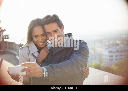 Couple taking self-portrait overlooking city Stock Photo